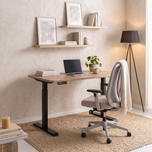 Szary fotel ergonomiczny Ease przy biurku z regulacją wysokości w domowym biurze