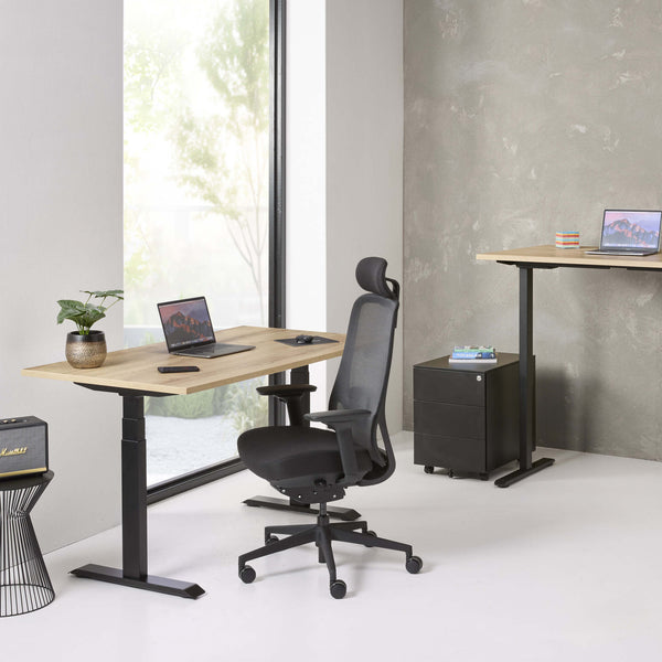 Czarny fotel ergonomiczny EasePRO przy biurku elektrycznym w domowym biurze